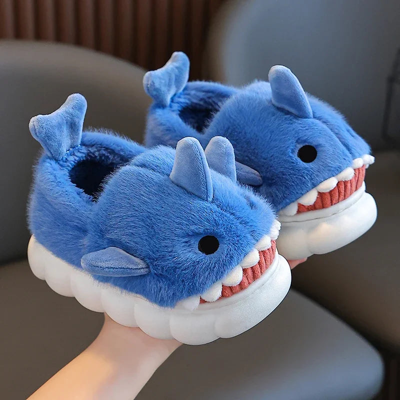 Chaussons pour enfants en forme de requin, couleur bleu, avec peluche douce et confortable. Dotés de nageoires latérales et de dents blanches amusantes, ils apportent un style unique et ludique. Parfaits pour garder les pieds au chaud tout en ajoutant une touche de fantaisie.
