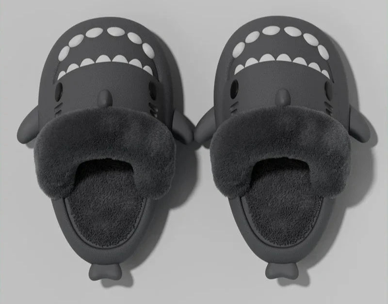 Pantoufles requin noires avec doublure en fausse fourrure douce et semelle antidérapante. Confortables et amusantes, parfaites pour l'hiver. Design ludique en forme de requin, idéal pour adultes et enfants.